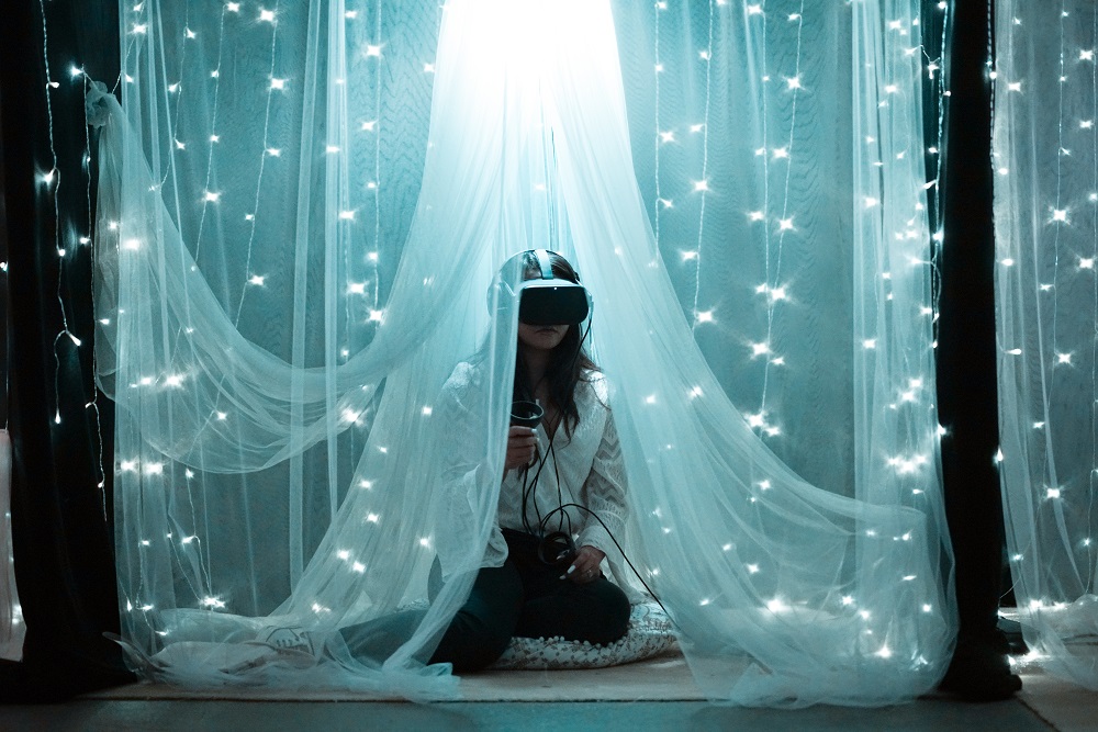 marketing in the metaverse. a woman wears a VR headset while shrouded in a canopy of fabric